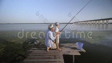 父子关系，慈爱的爸爸帮助他的孩子在河边的码头上打鱼，同时<strong>花钱</strong>